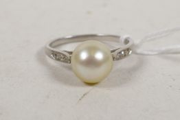A white metal ring, with diamond set shoulders and large pearl, 3.3g