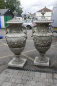A pair of large concrete garden urns and covers with classical style decoration, breaks down into