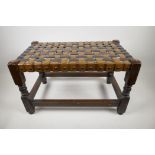 A wooden footstool with woven seat, 12" x 20" x 12"