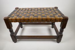 A wooden footstool with woven seat, 12" x 20" x 12"