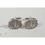 A pair of sterling silver cufflinks with relief decoration of a golfer