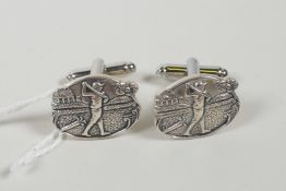 A pair of sterling silver cufflinks with relief decoration of a golfer