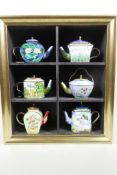 A display cabinet containing six 'Artists' collector's teapots by Goebel, 'Van Gogh' x 1, 'Monet'