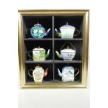 A display cabinet containing six 'Artists' collector's teapots by Goebel, 'Van Gogh' x 1, 'Monet'