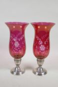 A pair of sterling silver and cranberry glass hurricane candlesticks with slice cut floral