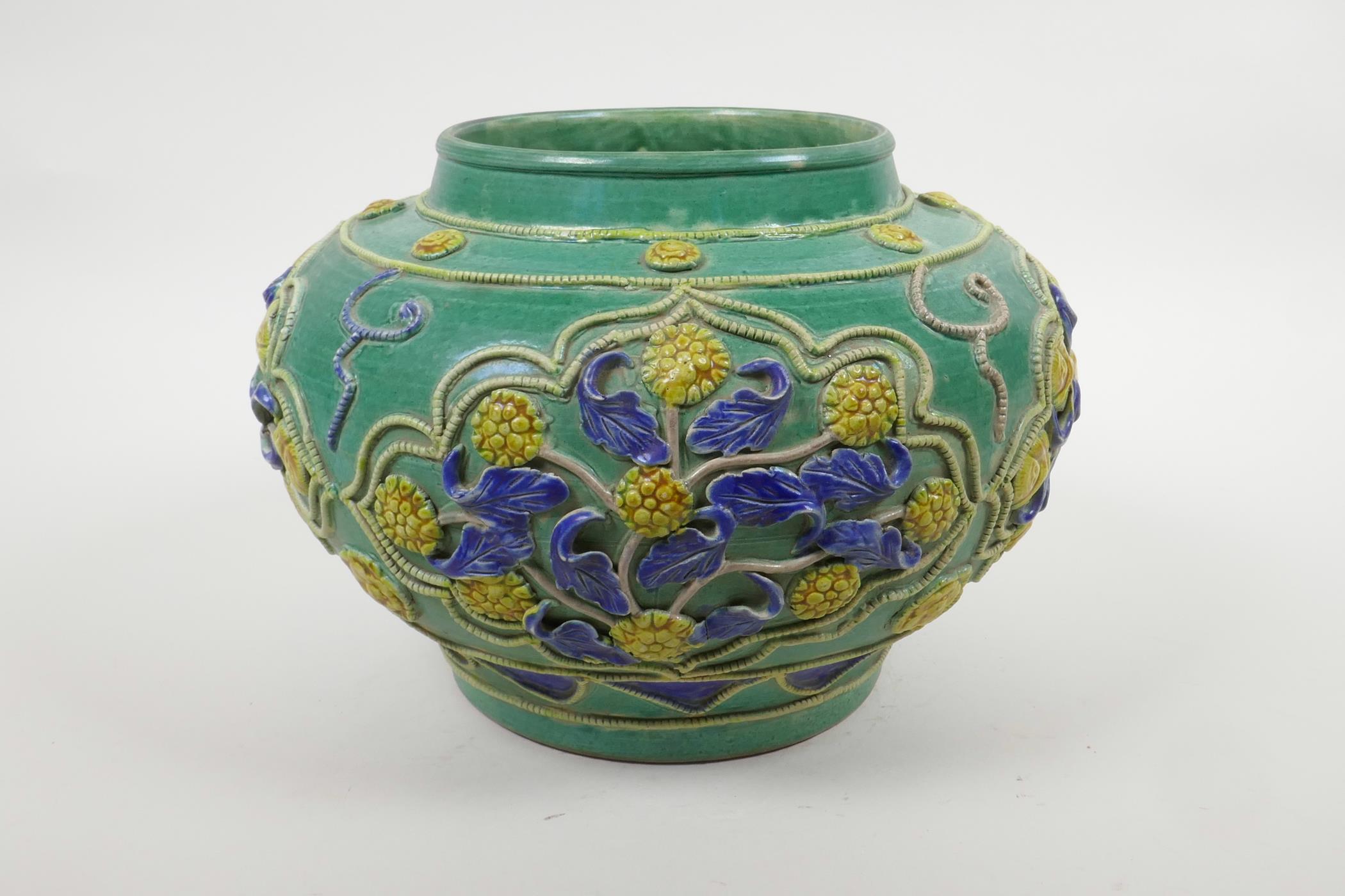 A Chinese green ground pottery vase with raised yellow and blue floral decoration, 9" diameter