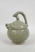 A Chinese celadon glazed pottery water dropper with raised floral decoration, the handle in the form