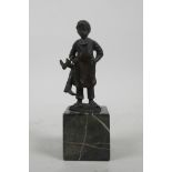 A bronze figure of a young boot maker, 5" high