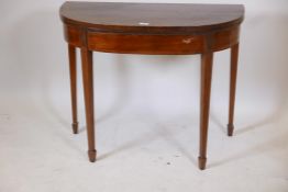 A C19th mahogany demilune card table with a crossbanded top on tapestry supports, 36" x 17½", 29"