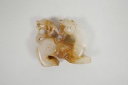 A Chinese carved white jade pendant in the form of a mythical creature, 2½" long