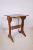 An Art Nouveau oak two tier occasional table with harewood inlay decoration to ends and shaped