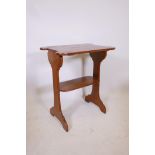 An Art Nouveau oak two tier occasional table with harewood inlay decoration to ends and shaped