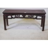 A C19th Chinese lacquered low table with a carved and pierced frieze, 41" x 12½" x 20" high