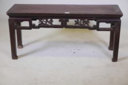 A C19th Chinese lacquered low table with a carved and pierced frieze, 41" x 12½" x 20" high