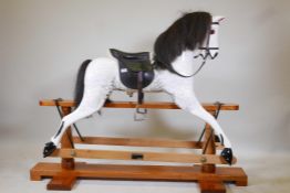 A large dappled painted pine rocking horse, maker's plaque affixed to base, 'Sunrise horses,