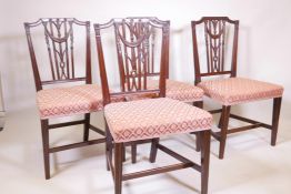A set of four C18th mahogany Hepplewhite chairs, with carved and pierced reeded backs decorated with