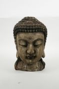 An oriental carved and painted Buddha head, 9½" high