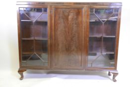 A 1930s mahogany bookcase with three doors, (two glazed), on cabriole supports, 53" x 9½" x 42½"