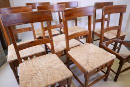 A set of eight rush seated fruitwood chairs with applied Dixy maker's plaque