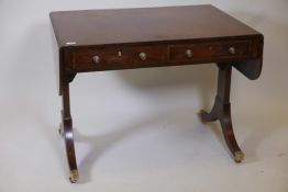 A C19th crossbanded mahogany sofa table on end supports with drawers and dummy drawers to each side,