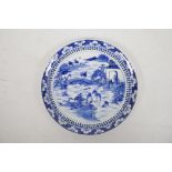 A Chinese blue and white plate decorated with figures engaged in various industries, fishing and