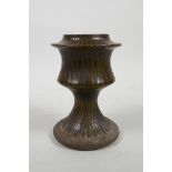 An early stoneware vase with a fluted body and treacle glaze, 5½" high