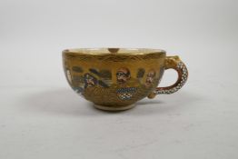 A Japanese Satsuma tea cup decorated with eight auspicious figures and a dragon, indistinctly signed