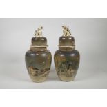 A pair of Japanese pottery jars and covers, decorated with waterfowl and petals, the covers with