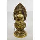A Chinese gilt filled bronze of Buddha seated on a lotus throne and holding a sceptre, four