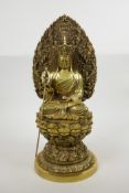 A Chinese gilt filled bronze of Buddha seated on a lotus throne and holding a sceptre, four