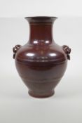 A Chinese copper glazed porcelain vase with two mask handles, seal mark to base, 9½" high