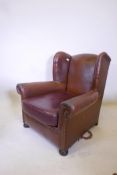A brown leather wing back arm chair, with a vinyl seat cushion, 34" high