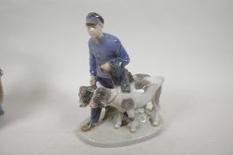 A Royal Copenhagen porcelain figurine of a boy with two calves, No 1858, 9" high, A/F