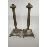 A pair of fluted column candlesticks on square form bases with elephant mask feet, 18" high