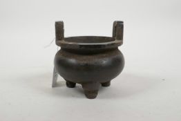 A Chinese bronze two handled censer raised on tripod feet, 4 character mark to base, 4" diameter