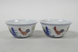 A pair of Chinese doucai porcelain tea bowls with chicken decoration, 6 character mark to base,