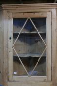 A C19th pine hanging corner cabinet, with glazed door and shaped shelves, 48" x 37"