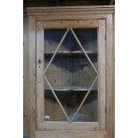 A C19th pine hanging corner cabinet, with glazed door and shaped shelves, 48" x 37"