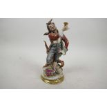 A Continental porcelain figure of a romanticised pirate with a peg leg, standing atop a treasure