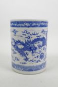 A Chinese blue and white porcelain brush pot decorated with a dragon and phoenix chasing the flaming