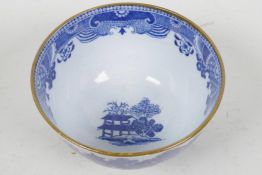 An early C19th English porcelain tea bowl, transfer printed with a variant on the Willow Pattern (