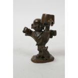 An Oriental bronzed metal figure of a boy practising martial arts and a piglet, impressed mark to