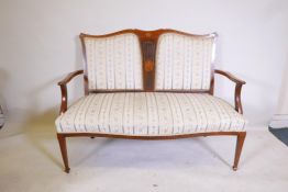 A Victorian inlaid mahogany open arm settee, with pierced and shaped back, raised on square tapering