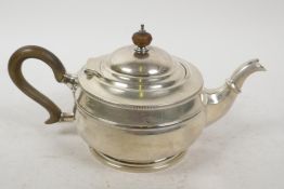 A hallmarked silver teapot with wooden handle and knop, gross 484 grams, marks rubbed