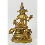 A Sino-Tibetan bronze figure of a deity seated on a mythical beast, double vajra mark to base, 8"