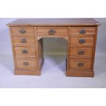 A Victorian ash kneehole desk with nine moulded front drawers, raised on a plinth base, 48" x 20"