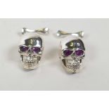 A pair of sterling silver skull cufflinks