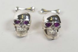 A pair of sterling silver skull cufflinks
