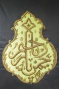 An Islamic wall hanging decorated with stumpwork script in gilt thread, 32" x 34"