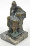 A stylised bronze figure of a seated, bearded man in Greek robes resting his head on his hand in a